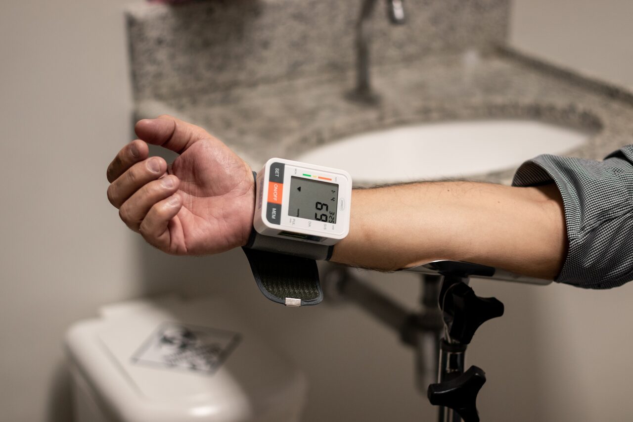 A wrist blood-pressure monitor showing a reading